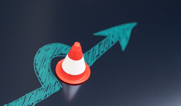 contract risk concept drawing of an arrow navigating around a traffic cone to avoid danger